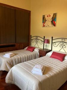 Ortigosa del MonteにあるCasa El Descanso Ortigosa del Monteのベッドルーム1室(赤い枕のベッド2台付)