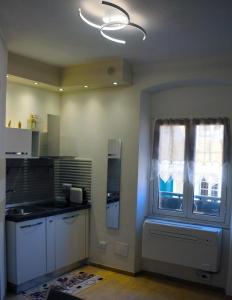a kitchen with white cabinets and a window at La Finestra del Pescò in Lerici