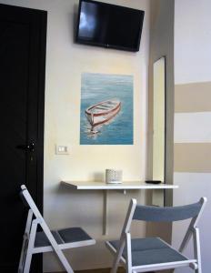 a room with two chairs and a table and a tv at La Finestra del Pescò in Lerici