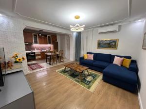 ein Wohnzimmer mit einem blauen Sofa und einem Tisch in der Unterkunft Chestnut Yard Villa in Tirana