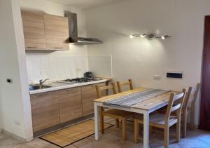 una cucina con tavolo, sedie e lavandino di CELESTE Central Apartment in Porto Rotondo with private parking a Porto Rotondo