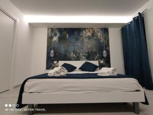 a bedroom with a large bed with a painting on the wall at Tropea Travel's House in Tropea +41 photos