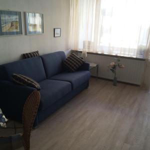 ヴェスターラントにあるFerienwohnung-Winoraのリビングルーム(青いソファ、テーブル付)