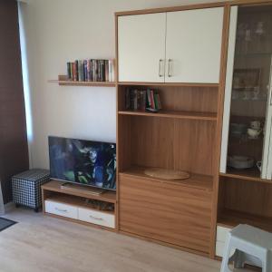 sala de estar con TV y estante de libros de madera en Ferienwohnung-Winora, en Westerland