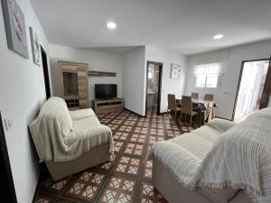 ein Wohnzimmer mit zwei Betten und einem Fernseher in der Unterkunft Alojamiento Los Alcornocales in Medina-Sidonia