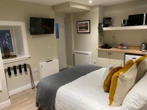 a bedroom with a white bed with yellow pillows at Greenbank, Lower Greenbank Guest Suite in Oban