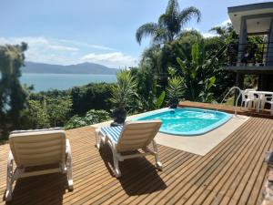 una terrazza con 2 sedie e una piscina di Suite com piscina e jacuzzi a Florianópolis