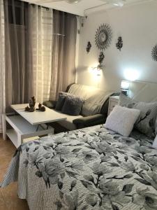 1 dormitorio con cama, mesa y sofá en La casita de Mercedes, en Puerto de la Cruz