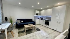 a living room with a blue couch and a kitchen at Apartment Hospodárska in Trnava