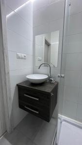 a white bathroom with a sink and a shower at Apartment Hospodárska in Trnava +10 photos
