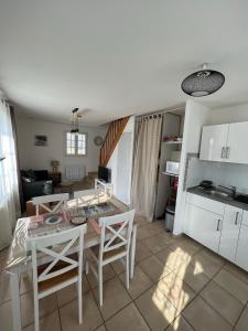 cocina y sala de estar con mesa y sillas en Maison de Charme en Saint-Règle