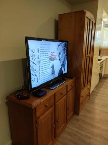 a flat screen tv sitting on top of a wooden cabinet at Casas da Eva - Alfragide in Alfragide