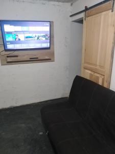 uma sala de estar com um sofá e uma televisão de ecrã plano em CASA GRANDE MEDELLIN em Medellín