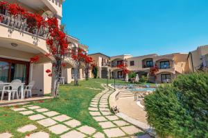 a courtyard of a building with red flowers at Residenza Pierre et Vacances Badus in Badesi