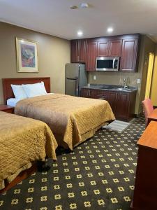 a hotel room with two beds and a kitchen at Niagara Lodge & Suites in Niagara Falls