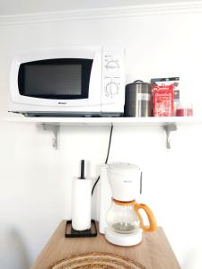 a microwave and a coffee maker on a shelf at Quiet and cosy studio near Cattenom, Luxembourg and Metz in Haute-Yutz