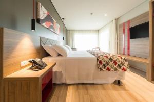 a hotel room with a bed and a telephone at Laghetto Stilo Borges in Gramado