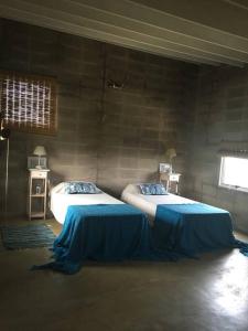 1 dormitorio con 2 camas y sábanas azules en Casa Xanelas, casa de playa en Punta Rubia, Rocha, en La Pedrera