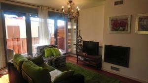 ein Wohnzimmer mit Sofa und Fernseher in der Unterkunft Las Margas. Golf. Bici. Esquí. Piscina. in Sabiñánigo