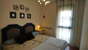 ein Schlafzimmer mit einem Bett und einem Fenster in der Unterkunft Las Margas. Golf. Bici. Esquí. Piscina. in Sabiñánigo