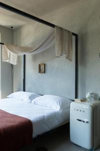 una camera da letto con un grande letto bianco a baldacchino di Agriturismo Olmo a Sondrio