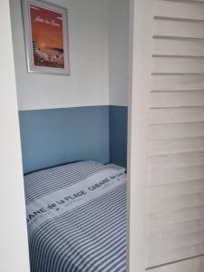 een kleine slaapkamer met een bed in een kleine kamer bij Studio Malouin - Sur la digue de Malo les Bains avec vue sur mer in Malo-les-Bains