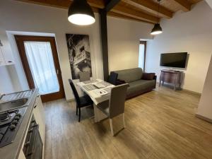 eine Küche und ein Wohnzimmer mit einem Tisch und einem Sofa in der Unterkunft DIVINA SAN ZENO in Verona