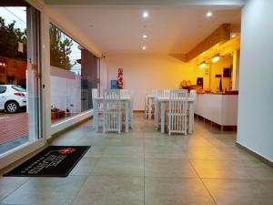 een restaurant met witte stoelen en een tafel en een bar bij Hotel Atlantis in San Bernardo