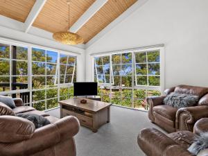 a living room with two couches and a tv at Erskine Beach House in Lorne