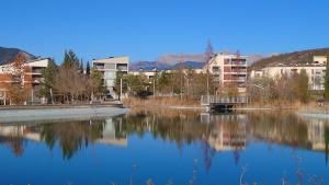 ein großer Wasserkörper mit Gebäuden im Hintergrund in der Unterkunft Las Margas. Golf. Bici. Esquí. Piscina. in Sabiñánigo