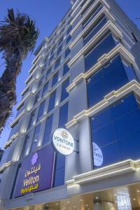 a tall building with a sign on the side of it at Veliton Hotel in Al Khobar