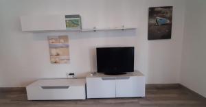 una sala de estar con TV en un armario blanco en Casa Punta de Los Ingleses, en Punta Umbría