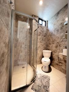 La salle de bains est pourvue d'une douche et de toilettes. dans l'établissement Hotel Hai Do, à Bernal