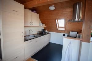 een keuken met witte kasten en een wastafel bij Tórshavn - Central - City & Ocean Views - 3BR in Tórshavn