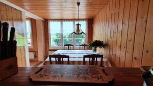 ein Esszimmer mit einem Tisch, Stühlen und einem Fenster in der Unterkunft Adlerhorst - Apartment im Niedersimmetal in Oey