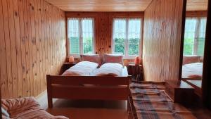 a bedroom with two beds and two windows at Adlerhorst - Apartment im Niedersimmental in Oey