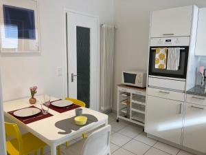 una cucina con tavolo e frigorifero bianco di Appartamento con giardino al Melograno a Locarno