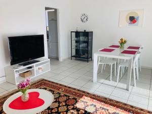 sala de estar con mesa y TV en Appartamento con giardino al Melograno, en Locarno