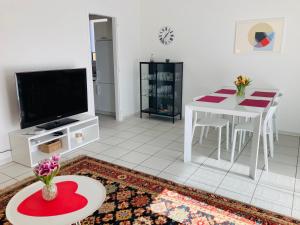 a living room with a table and a tv at Appartamento con giardino al Melograno in Locarno