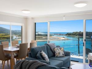 
a living room filled with furniture and a lake at Sapphire Waters Unit 3 in Narooma
