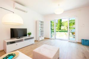 a living room with a television and a couch at Apartment Barbina Kaštelina in Sveti Juraj