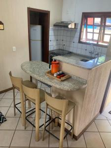 una cucina con isola, sedie e piano di lavoro di Casa em Juquehy localização e lazer perfeitos para família a São Sebastião