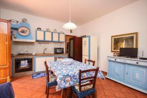 a kitchen with a table and a refrigerator at Casa Buscarini in Santa Flavia