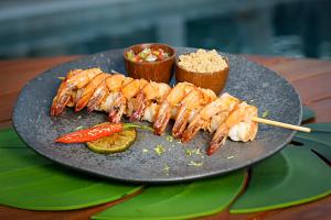 a plate of food with skewers of food on a table at Paraiso Beach Hotel in Aquiraz
