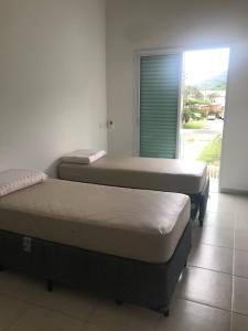 three beds sitting in a room with a window at ACONCHEGO EM FAMÍLIA_JUQUEHY in Juquei +28 photos