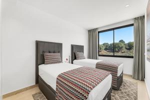 two beds in a room with a window at Oasis by the Sea in La Cala de Mijas (La Valvega) in Mijas Costa +31 photos