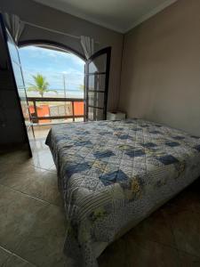a bedroom with a bed with a view of the ocean at Pé na areia gaivotas com Wi-Fi in Itanhaém