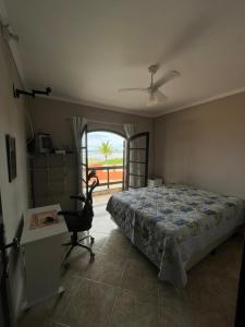 - une chambre avec un lit, un bureau et une fenêtre dans l'établissement Pé na areia gaivotas com Wi-Fi, à Itanhaém