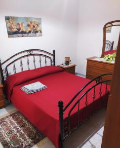 Buggerru Vacanze في بوجيرو: غرفة نوم بسرير احمر مع بطانية حمراء