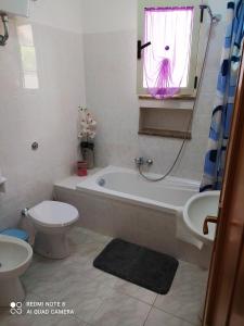 Buggerru Vacanze في بوجيرو: حمام مع حوض ومرحاض ومغسلة